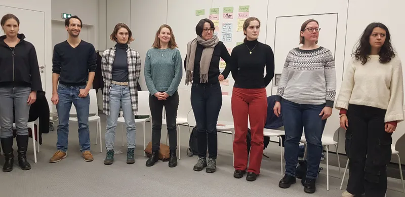 Ein Team posiert vor einem Stuhl mit einem lässigen Style. Die Outfits beinhalten Jeans, Sneaker, Stiefel und Sonnenbrillen. Ein modisches Ensemble für ein E...