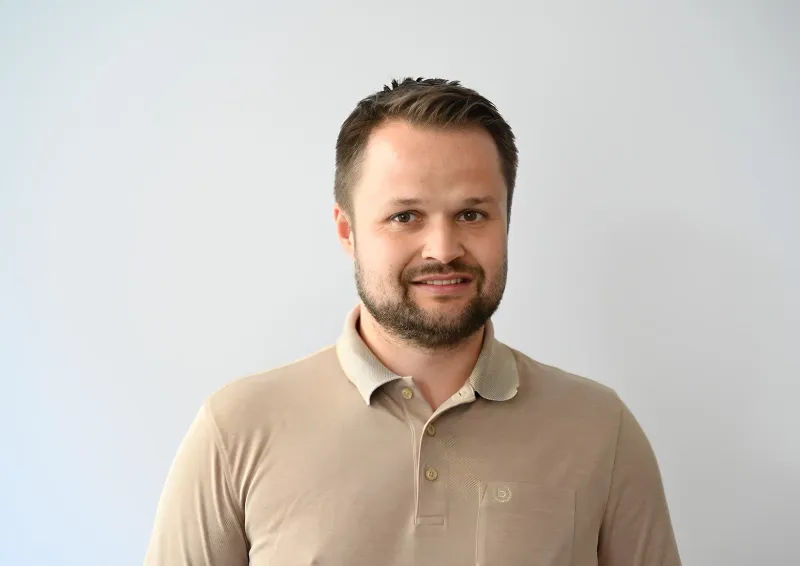 Christian Leu, Stellvertretender BDL-Bundesvorsitzender, lächelt in die Kamera. Er trägt ein weißes Hemd und wird von einem Blitzlicht beleuchtet.