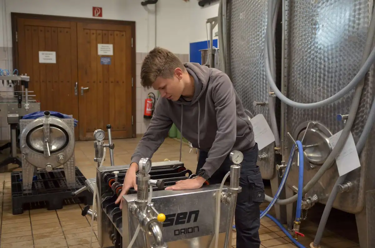 Junge:r Winzer:in mit technischen Geräten