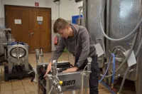 Junge:r Winzer:in mit technischen Geräten