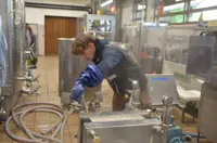 Junge:r Winzer:in mit technischen Geräten