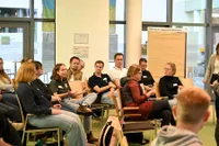 Eine junge Frau spricht in einer Runde