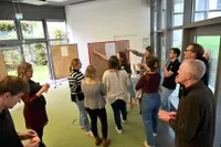 Eine Gruppe Junger Menschen arbeitet zusammen an einer Pinnwand