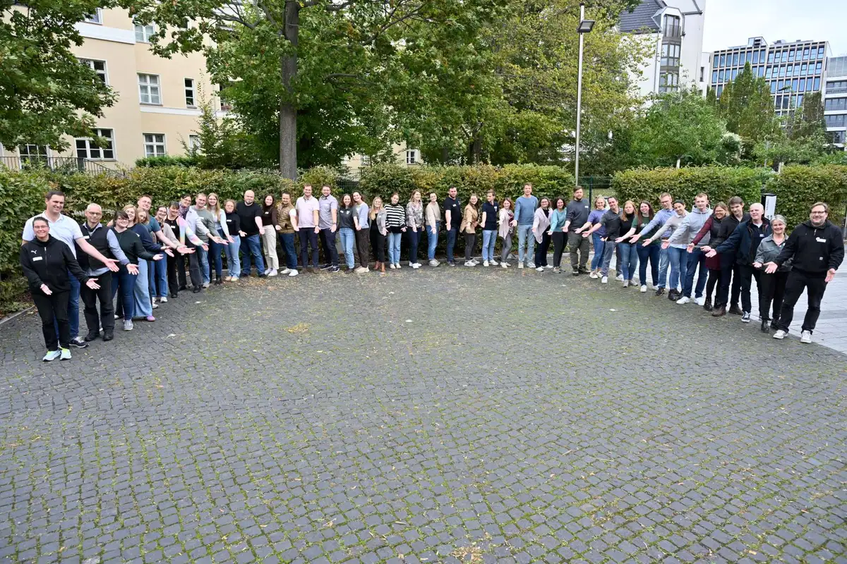 Eine große Gruppe Menschen steht in einem Halbkreis
