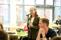 Teilnehmerin spricht am Mikrofon mit Plüschratte