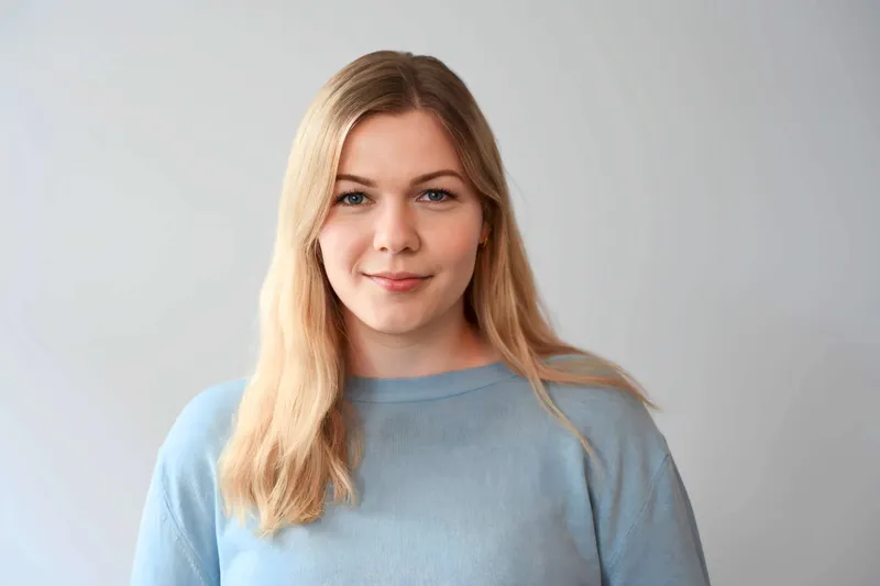 Theresa Schmidt, Bundesvorsitzende des BDL, lächelt in die Kamera. Sie trägt ein blaues Hemd mit langem Ärmel und zeigt mit der Hand eine Geste. Die Aufnahme...