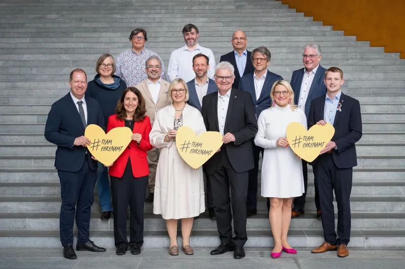 Engagierte und Abgeordnete mit #TeamEhrenamt-Herzen vor dem Bundestag