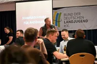 Ein Lächelnder Mann präsentiert einen "Schwäbischkurs für Anfänger"