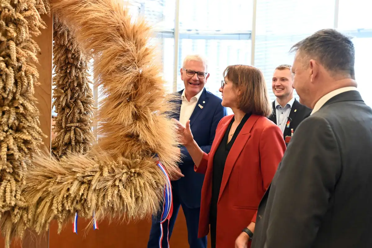 Landjugend mit Schleswig-Holsteiner Erntekrone und dem Vorsitzenden des LEH-Bundestagsausschusses im Sitzungssaal.