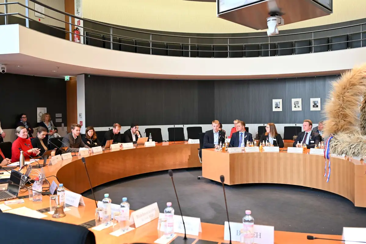 Landjugend mit Schleswig-Holsteiner Erntekrone und dem Vorsitzenden des LEH-Bundestagsausschusses im Sitzungssaal.