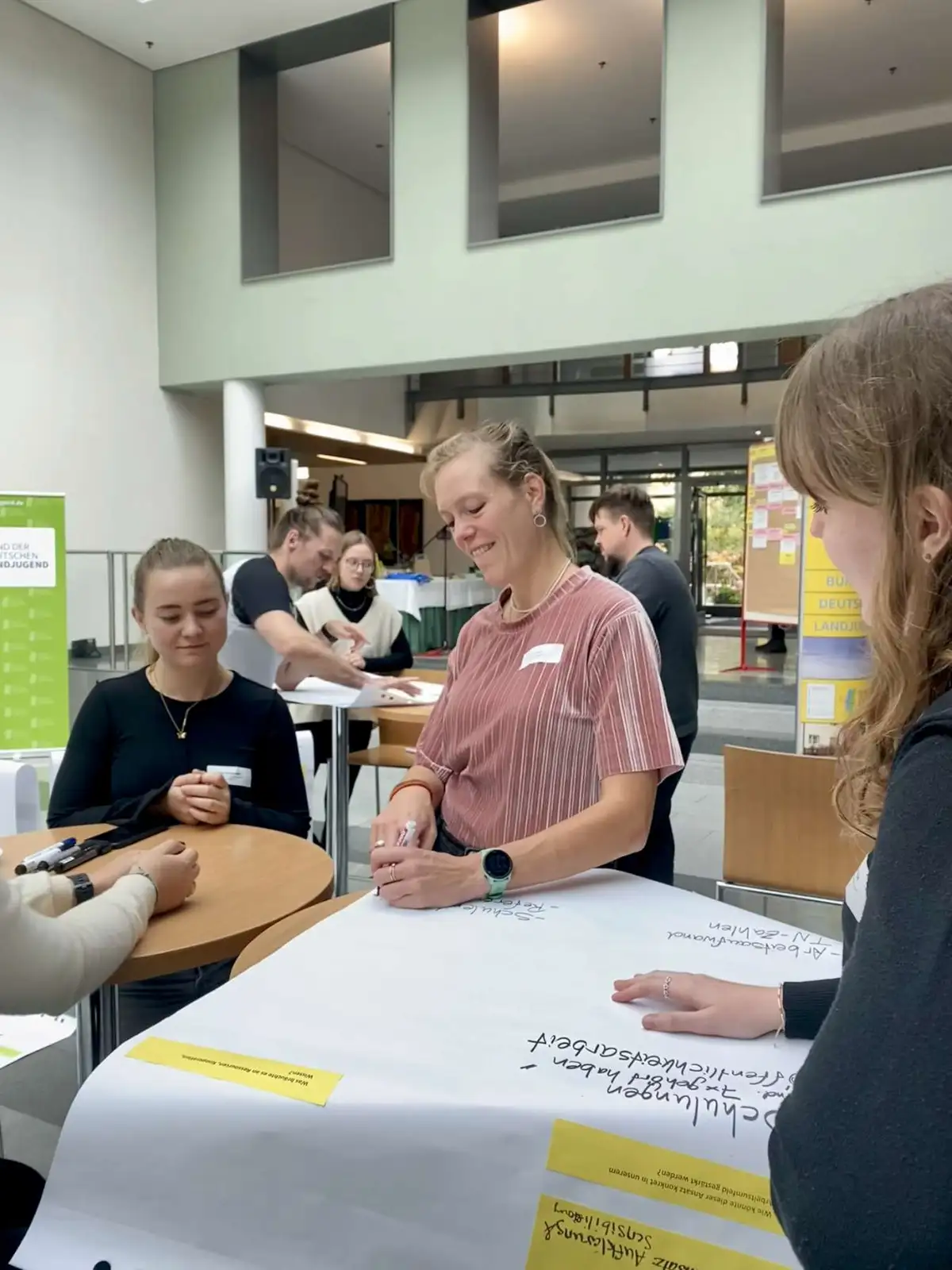 Eine junge Frau schreibt auf ein Plakat