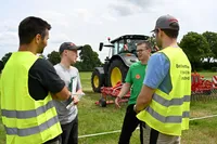 Junge Landwirte vor Traktoren