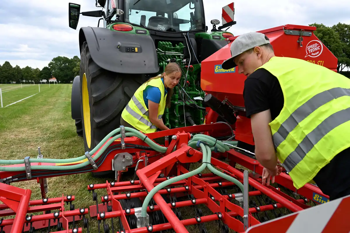 Junge Landwirt:in vor Traktoren