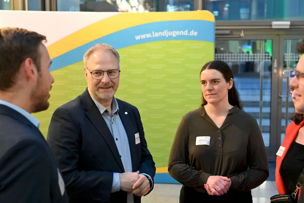 Vier Personen im Gespräch vor einem BDL Banner