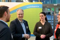 Vier Personen im Gespräch vor einem BDL Banner