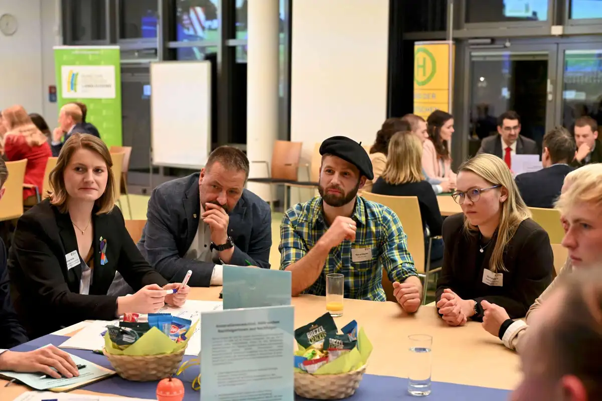 Fünf Personen hören einem Diskussionsbeitrag zu