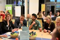 Fünf Personen hören einem Diskussionsbeitrag zu