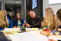 Teilnehmer teilt seinen Standpunkt in einer Tischrunde