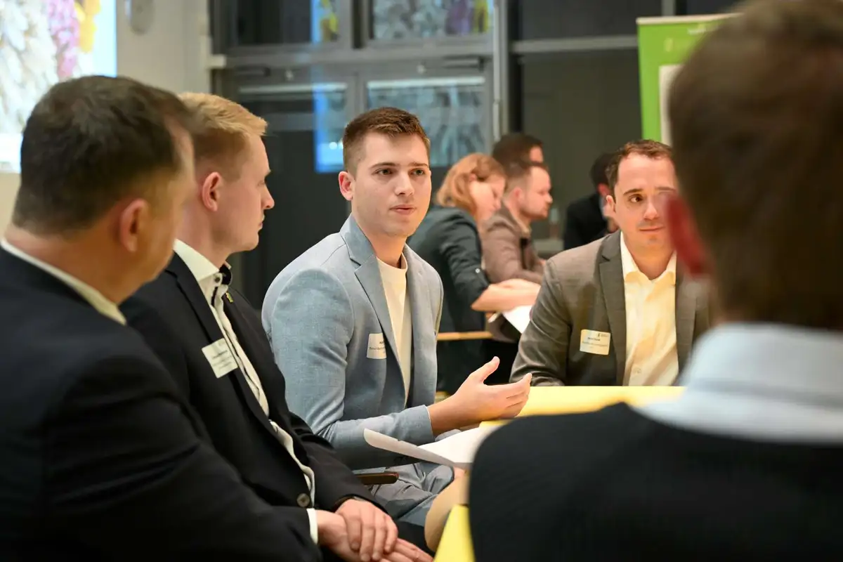 Diskussionsteilnehmende an einem Tisch
