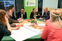Junge Menschen diskutieren in einer Tischrunde