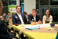 Junge Menschen sitzen abwartend an einem Tisch