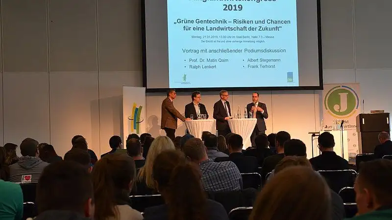 Sall mit Personen auf einer Bühne