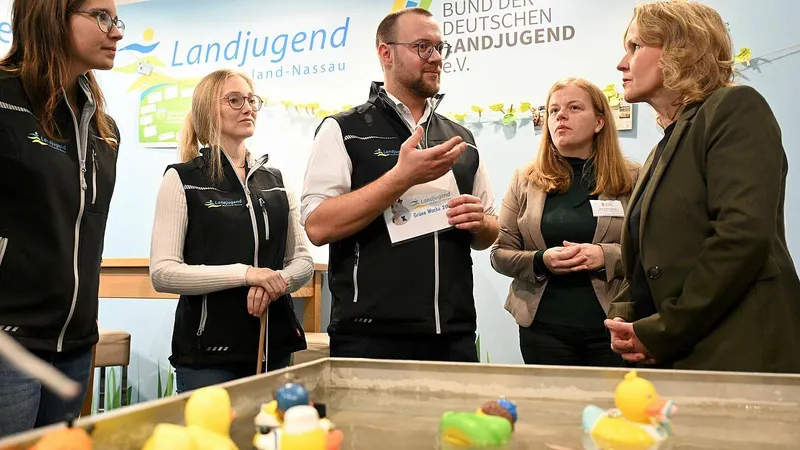 Eine Gruppe von Menschen in bunten Jacken und Mänteln beim gemeinsamen Treffen. Sie tragen gelbe und grüne Kleidung und scheinen sich an eine neue Umgebung a...