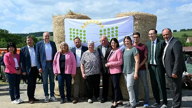 Personen vor einem Heuballen